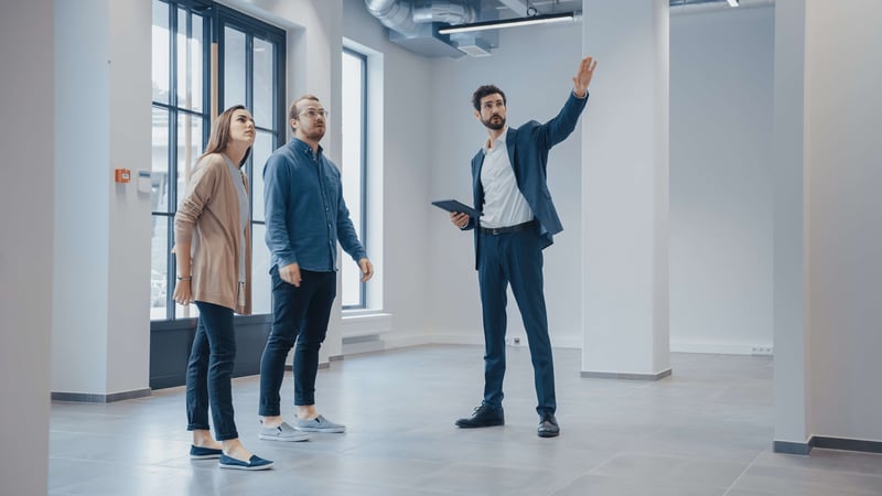 A commercial real estate agent showing a property to two potential investors.