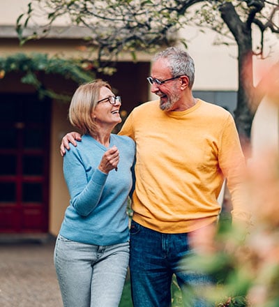 Senior couple holding standing outside their new house