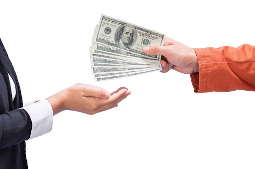 Man handing another person a stack of 100-dollar bills from a private line of credit